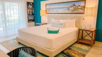 A neatly made bed with a pillow labeled "Changes in LATITUDE," a teal woven basket, and a wooden nightstand with a lamp.