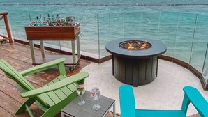 Une terrasse dotée de mobilier d’extérieur, d’un foyer et offrant une vue sur l’océan.