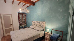 A bedroom with a bed, a nightstand, a chair, and a ceiling fan. - Carducci bright flat in historic centre (Pistoia)