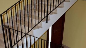 A staircase with a black metal railing and beige steps. - B&B Federico II (San Cipirello)