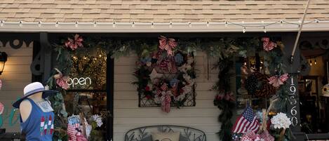 A building with a gabled roof, a front porch with a bench, and a Christmas wreath.