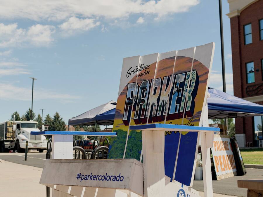 A sign for the Parker Chamber of Commerce with a hashtag #parkercolorado.