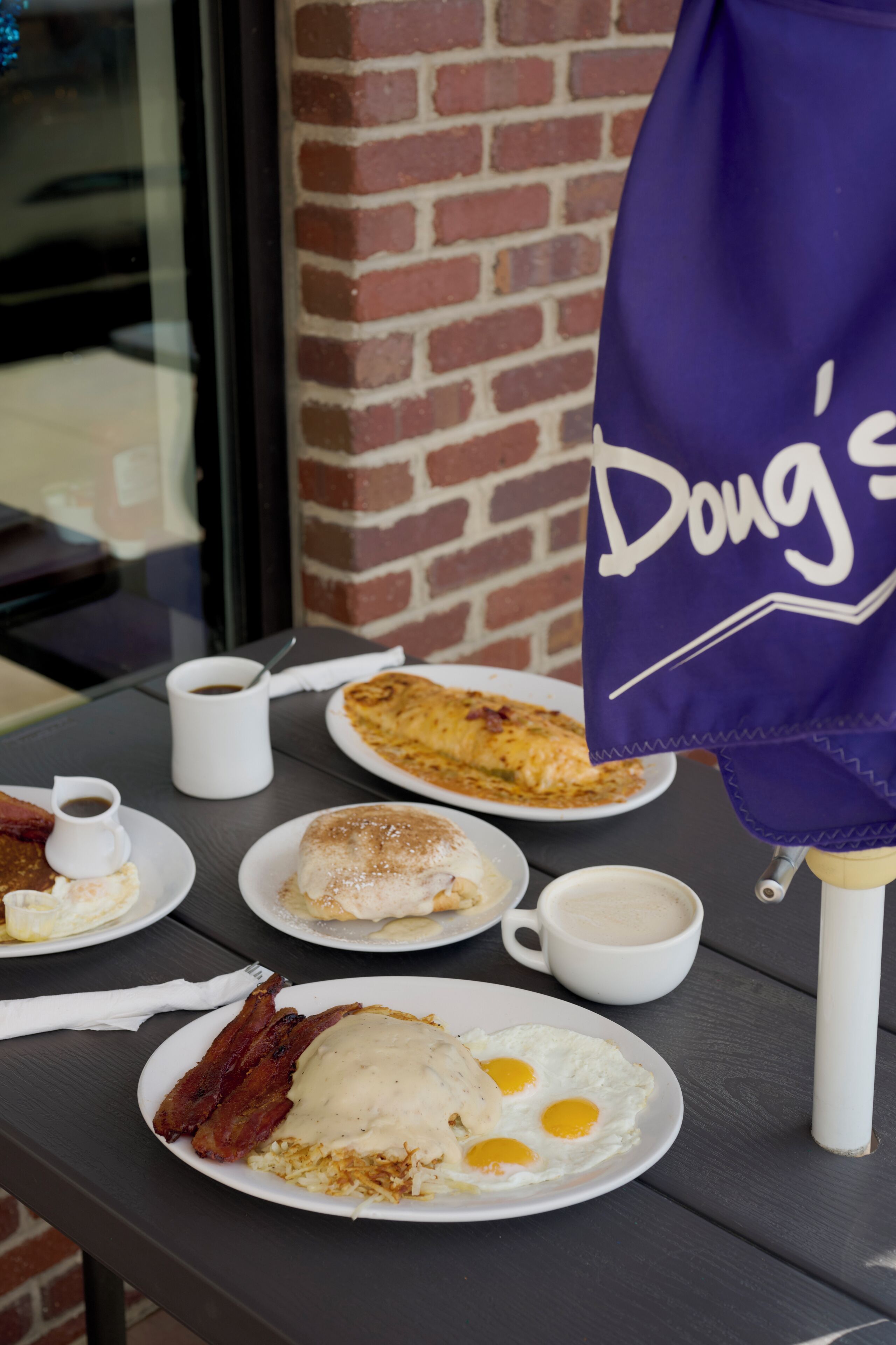 Una mesa de desayuno con platos de comida, tazas y una bandera.