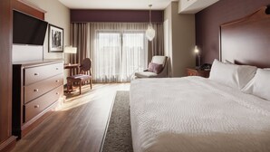 A hotel room with a large bed, a desk with a chair, a television, and a window with curtains. - The Parker Hotel (Parker)