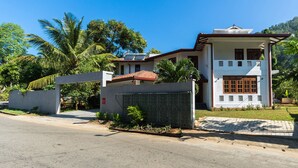 A two-story house with a white exterior, a red-tiled roof, and a covered entrance. - Niru Residence (Kandy)
