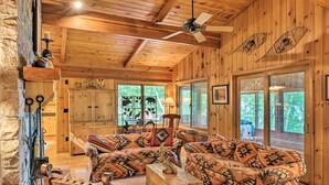 A cozy cabin interior with a wooden ceiling, a sofa set, a fireplace, and large windows. - Rustic Cozy Cabin on Island Lake w/ Fire Pit, Dock (Park Rapids)