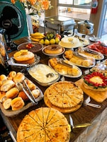 A buffet table with various food items and utensils.