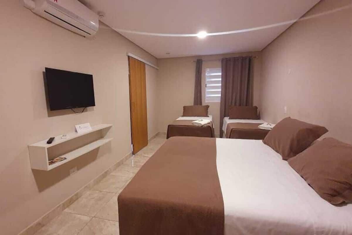 Une chambre d’hôtel avec un grand lit, une télévision, un bureau et une chaise.