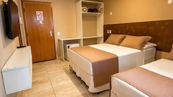 Une chambre d’hôtel avec deux lits, une armoire, un bureau et un téléviseur.