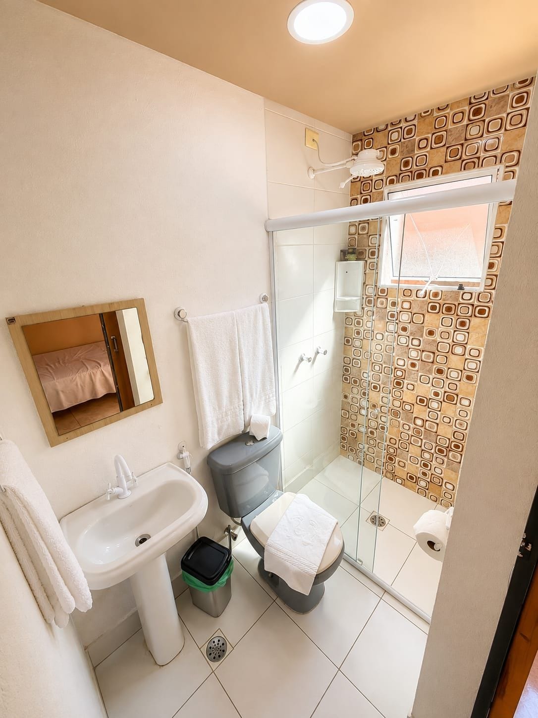Et badeværelse med toilet, bidet, vask og bruseområde.