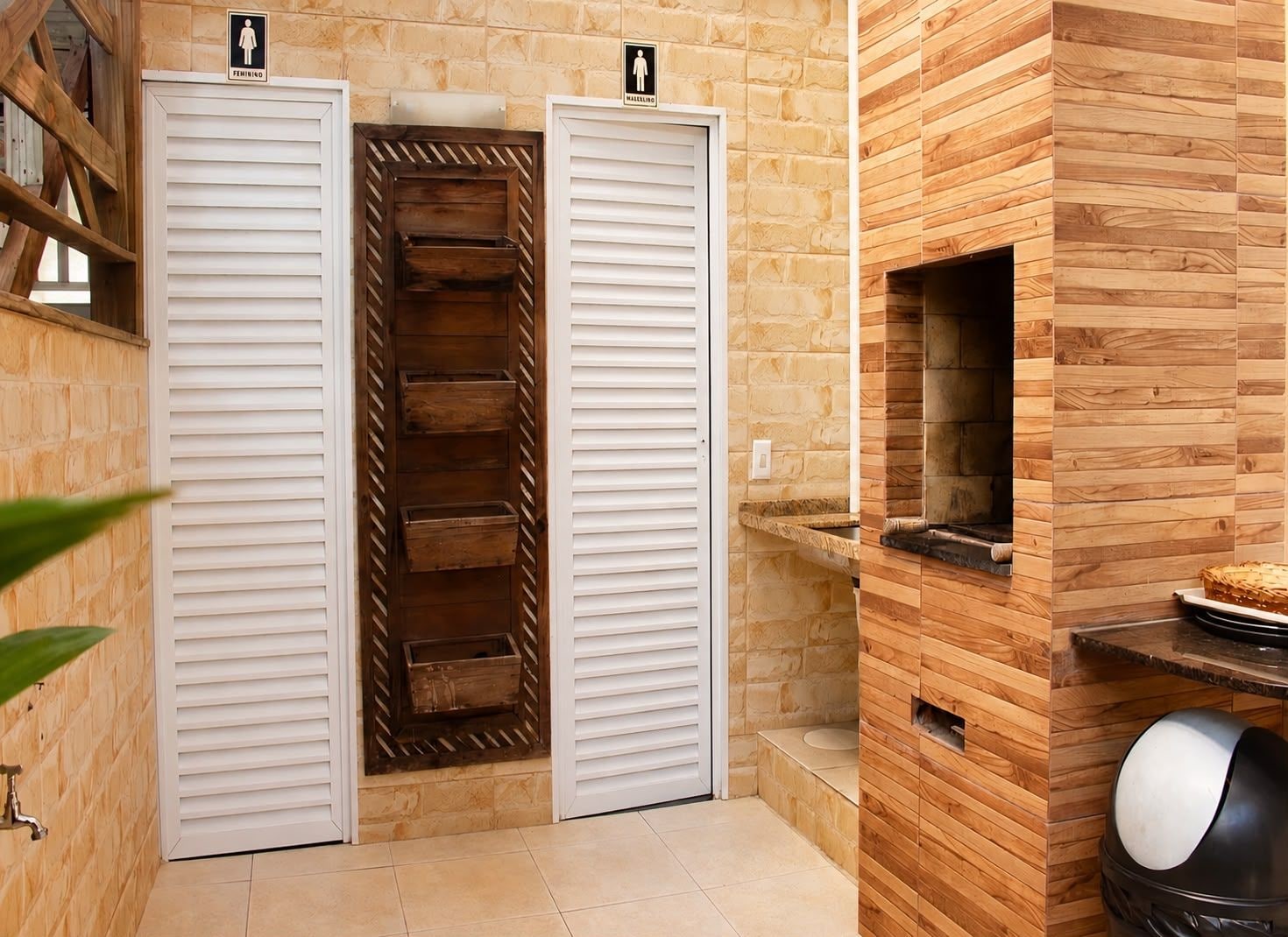 A bathroom with two white cabinets, a wooden shelf, and a tiled floor.