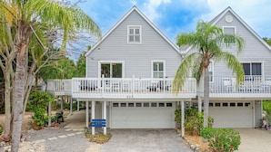 A two-story house with a covered porch and a garage. - Tropical Anna Maria Island Villa (Holmes Beach)