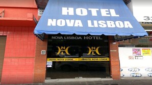 The exterior of Hotel Nova Lisboa with a prominent blue awning and a visible Visa sign. - Hotel Lisboa (Curitiba)