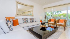 Uma sala de estar moderna com sofá, mesa de centro e cadeiras de vime.