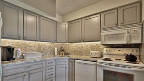 A kitchen with grey cabinets, a microwave, a stove, and a dishwasher. - Charming, Renovated 2BR/2BA Mt Green Condo: Steps to Killington 3C13/A (Killington)