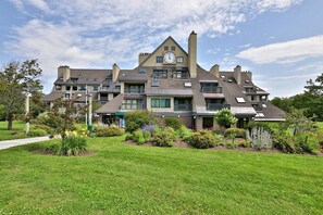 A multi-story building with a clock on the facade, surrounded by well-maintained lawns and various plants. - Charming, Renovated 2BR/2BA Mt Green Condo: Steps to Killington 3C13/A (Killington)