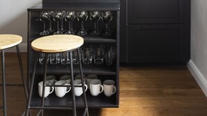 A compact kitchen with a black countertop, a built-in microwave, and a wine rack. - Via del Tritone (Rome)