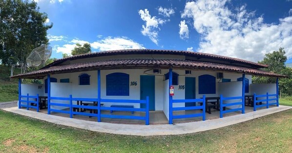 A building with a tiled roof and blue-framed windows, numbered 106 and 105. - Tijota Park Hotel Fazenda (Santana Do Paraiso)