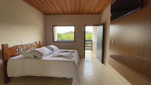 A bedroom with a wooden ceiling, a bed with white linens, two windows, and a view of greenery outside. - Tijota Park Hotel Fazenda (Santana Do Paraiso)