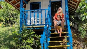 A blue and yellow house with a staircase leading to a balcony. - Tijota Park Hotel Fazenda (Santana Do Paraiso)