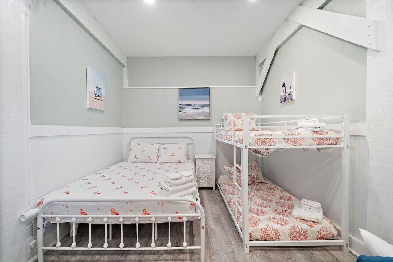 A bedroom with a bunk bed and a single bed, both with patterned bedding.