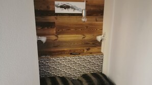 Una habitación pequeña y acogedora con cabecera de madera, pared con diseño y una cama sencilla.