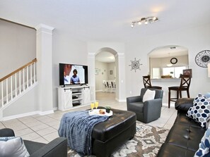 Relax in a spacious living room with a flat-screen TV, comfortable seating area, and patterned rug.
