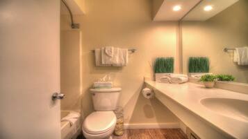 Een bad/douchecombinatie, een haardroger, handdoeken