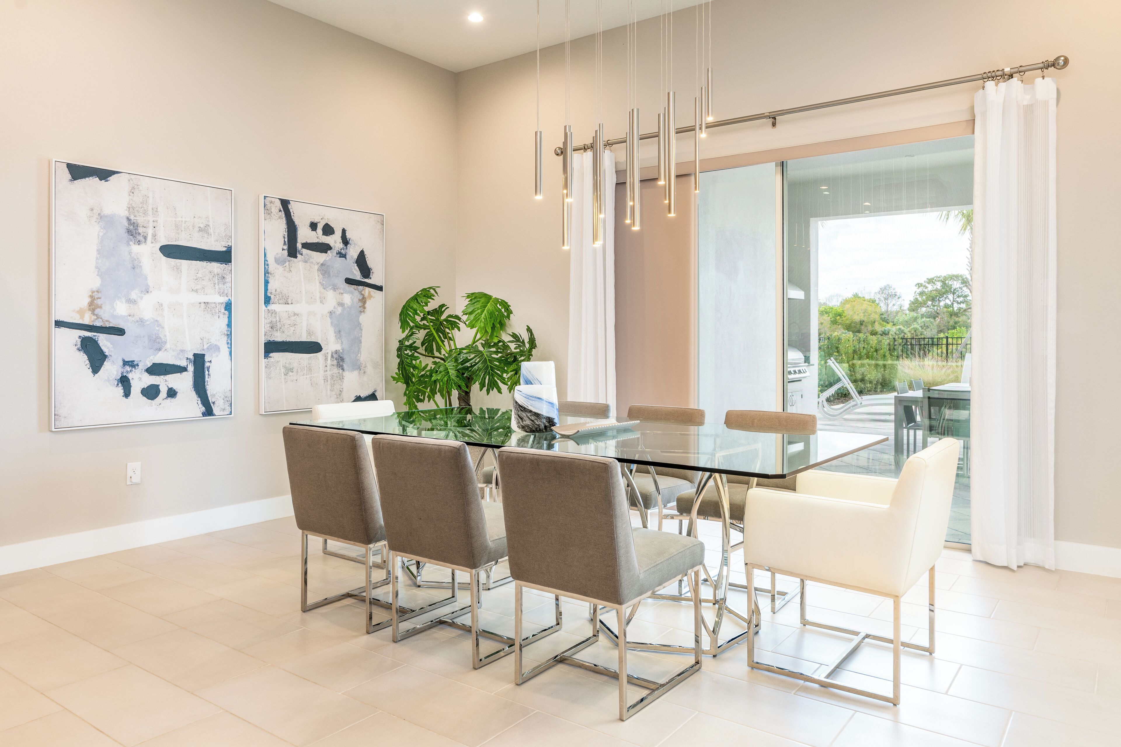 A modern dining area with a glass table, four chairs, and abstract art on the wall.