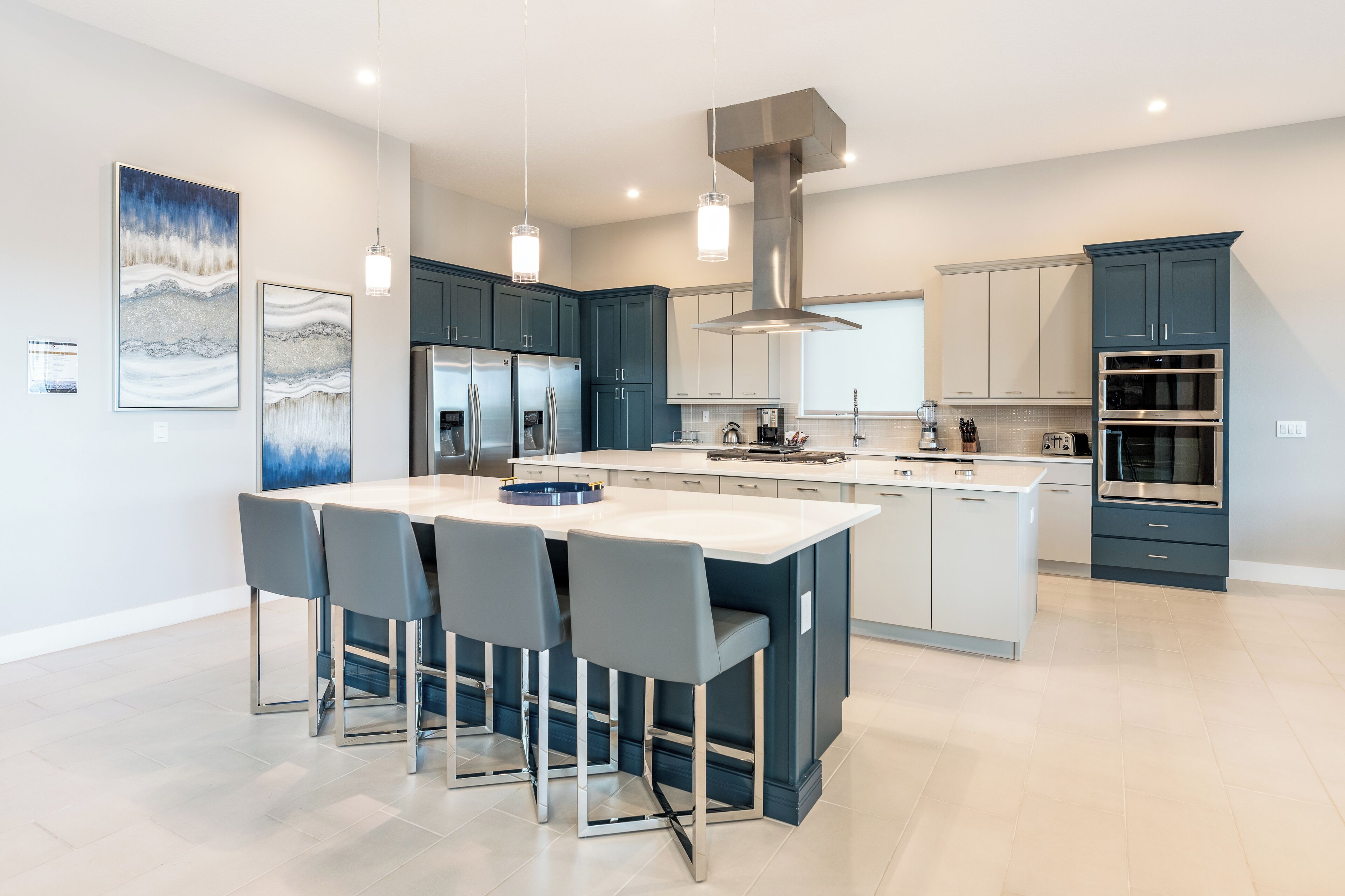 Een moderne keuken met een centraal eiland, roestvrijstalen apparatuur en een groot raam.