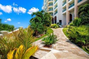 Stroll through the lush courtyard, surrounded by tropical plants and palm trees, and access your room via one of the many balconies with glass railings.