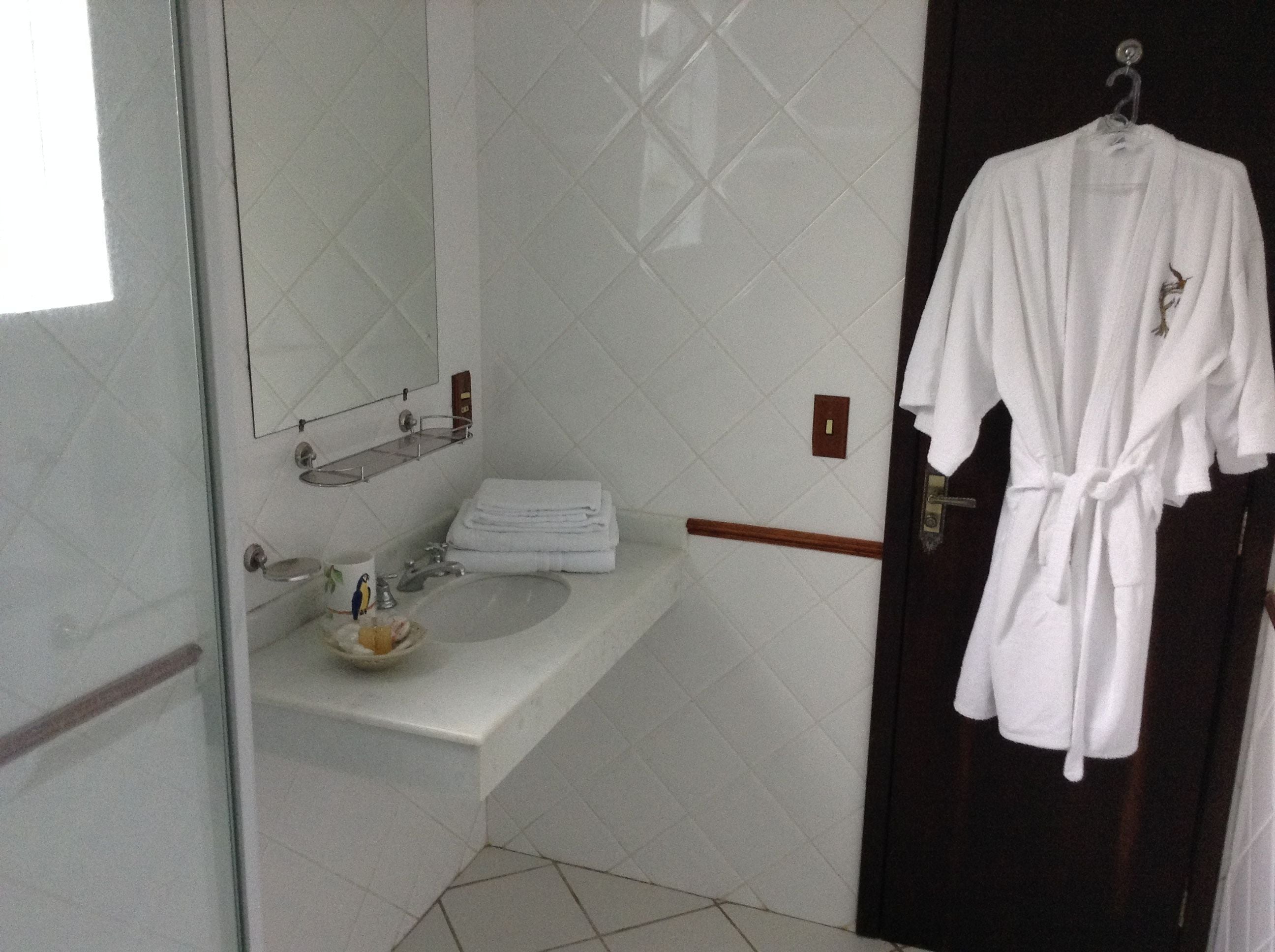 A bathroom with a white sink, a mirror, and a towel rack.