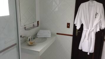 A bathroom with a white sink, a mirror, and a towel rack.