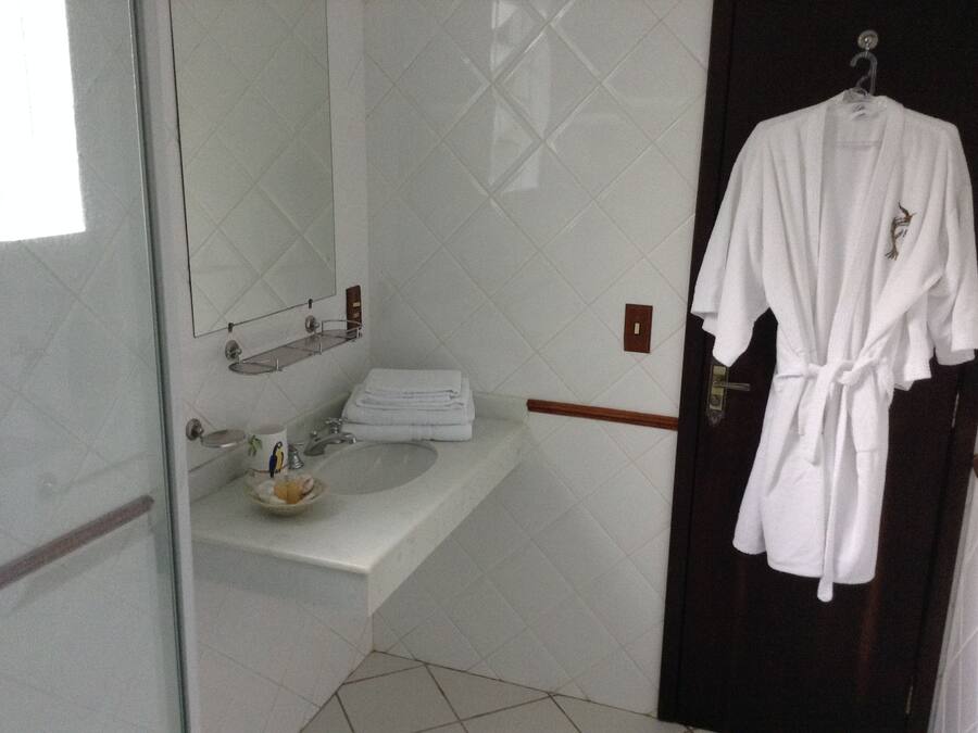A bathroom with a white sink, a mirror, and a towel rack.