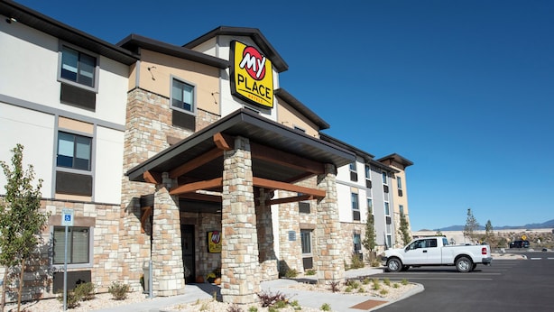 Een My Place hotel met een stenen gevel, meerdere ramen en een overdekte ingang.