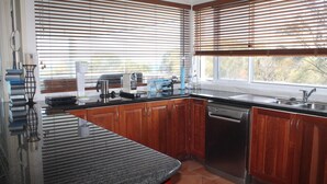 Una cocina moderna con armarios de madera, encimera negra y lavavajillas.