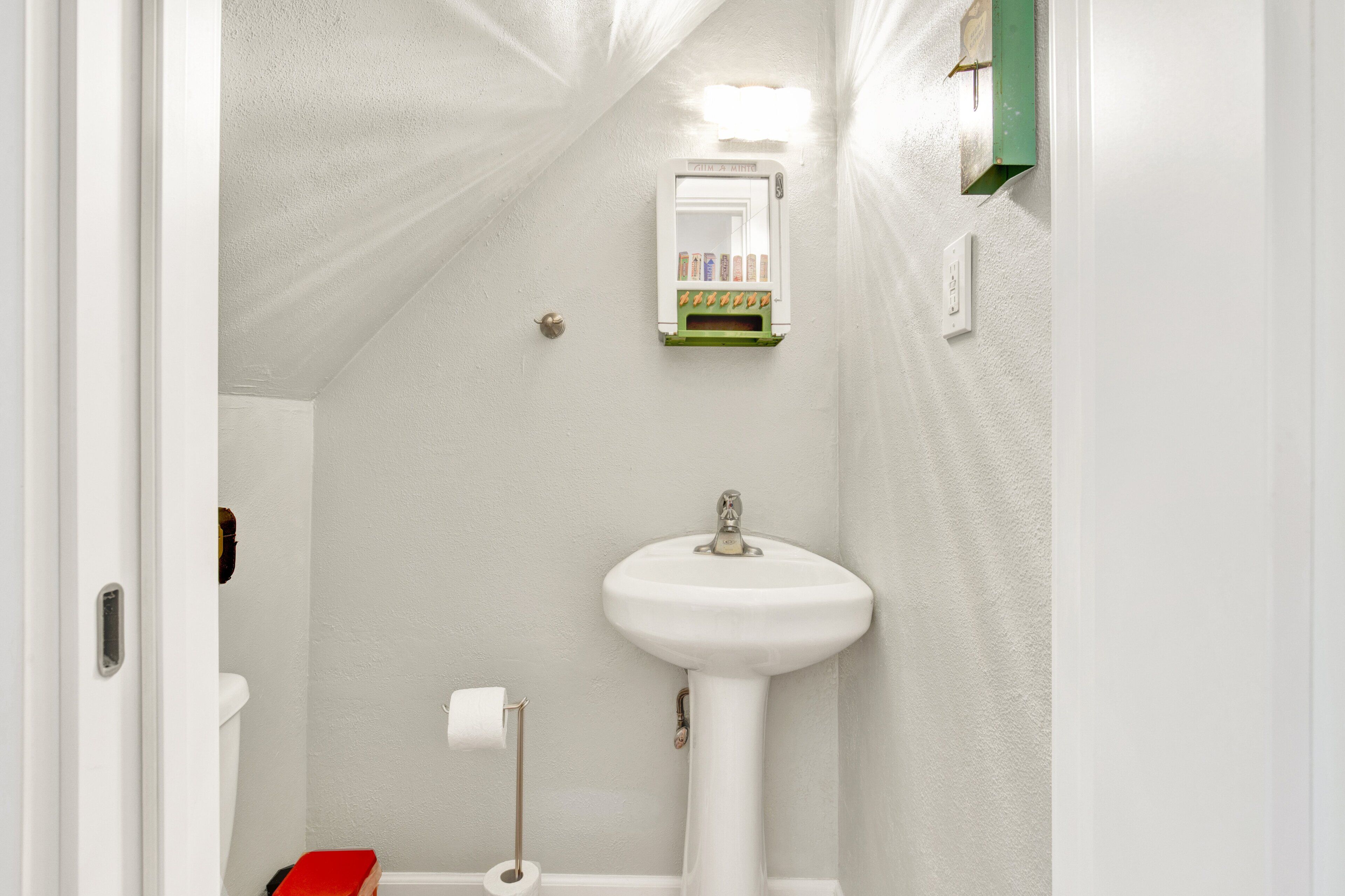 A bathroom with a white sink, a mirror, and a toilet.