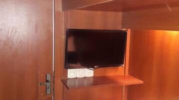 A bunk bed with a television mounted on the wall above it.