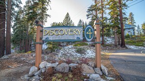 Schild für Discovery Condominiums mit der Nummer 4, umgeben von Bäumen und einer verschneiten Landschaft.