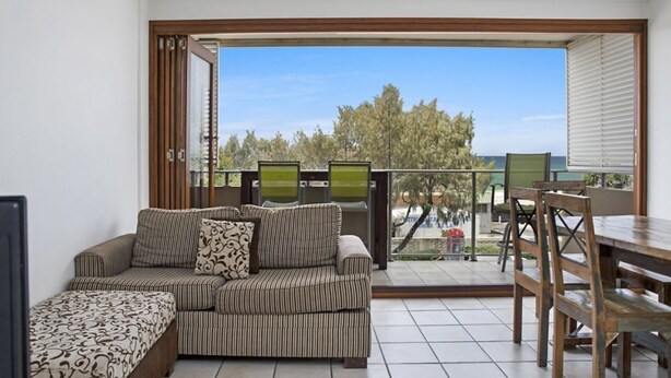 A balcony with a sofa, chairs, and a table.