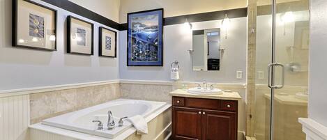 A modern bathroom with a bathtub, vanity, and walk-in shower.