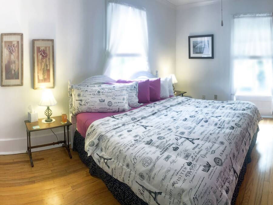 A bedroom with a bed, bedside tables, a chair, and a wardrobe.