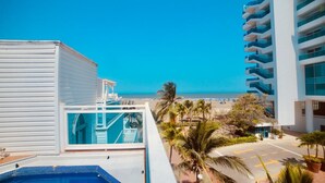 A hotel with a pool, a view of the beach, and a parking area. - Hermosa Casa Playera (Cartagena)