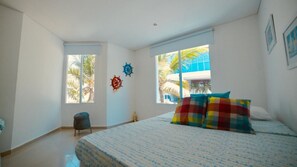 Camera da letto con un letto, due finestre, una sedia e decorazioni alle pareti.
