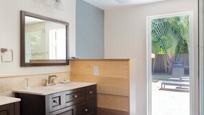 A bathroom with a dark wood vanity, a mirror, and a light-colored countertop. - Blue Tempo - Steps to Wilton Dr, Heated Salt Pool, Huge Yard (Wilton Manors)