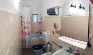 Een bad/douchecombinatie, een haardroger, een bidet, handdoeken