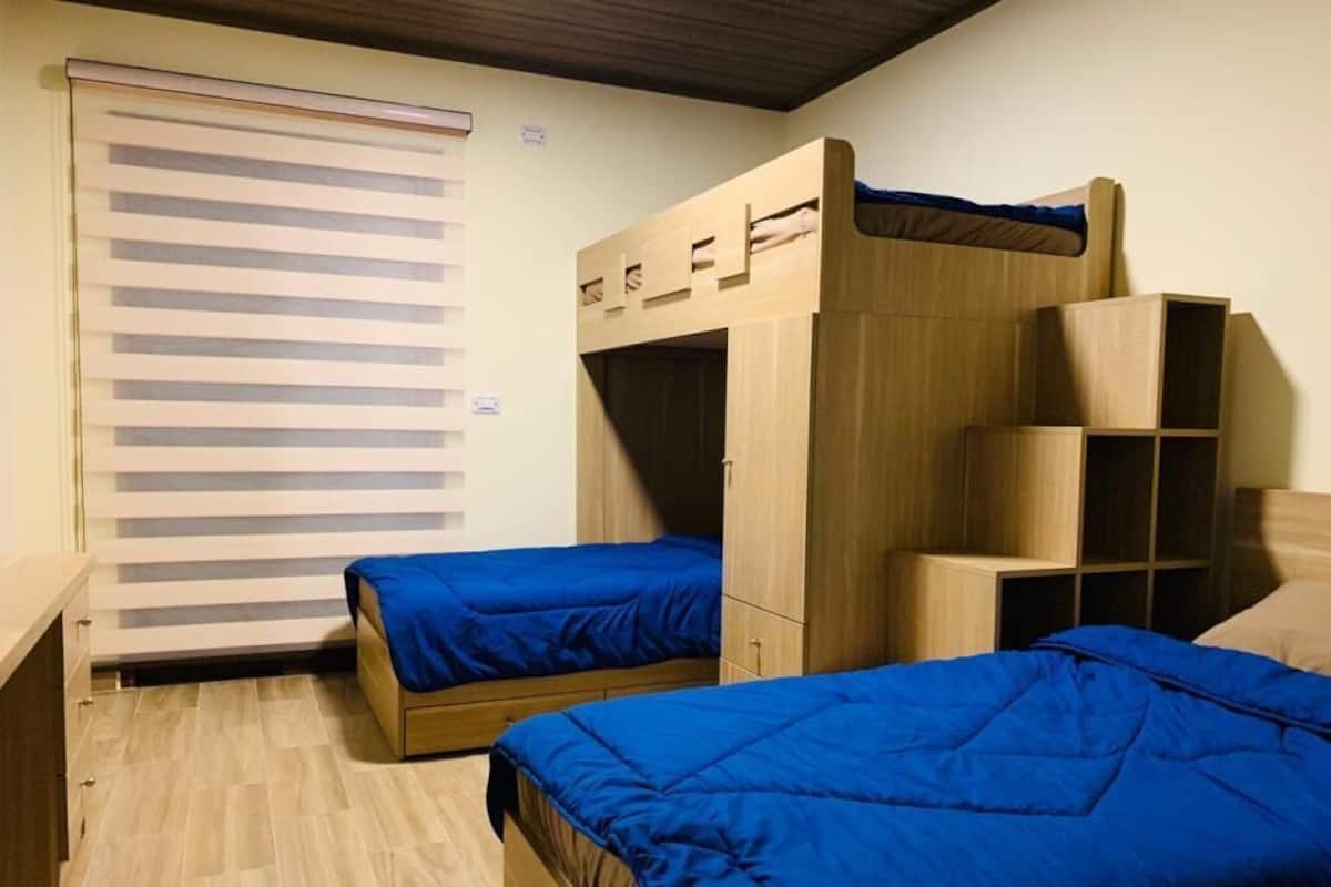 A room with two bunk beds, a sliding door, and built-in storage.