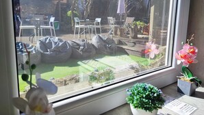 A window view of a patio area with outdoor seating and potted plants. - Ruby Charm Houses 8 66132/AL (Porto)