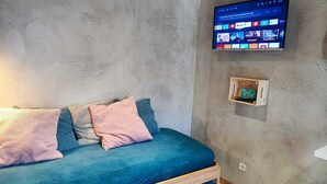 A room with a bed, a mounted TV, and a small wooden shelf. - Ruby Charm Houses 8 66132/AL (Porto)