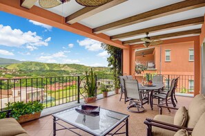 A balcony with a glass table, chairs, and potted plants. - Luxury Ground Floor Condo, close to pool access to beach club at Los Suenos. (PUNTARENAS)